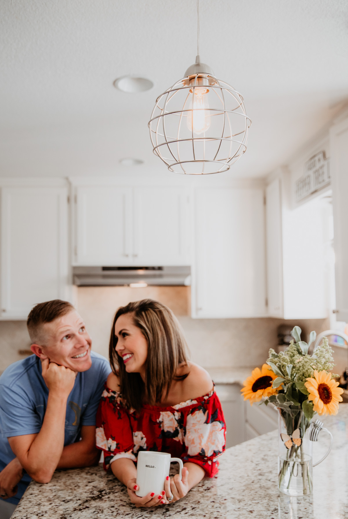 Brushed nickel farmhouse pendant light with round cage shade hanging over kitchen bar from Worth Home Products recessed lighting conversion kit.