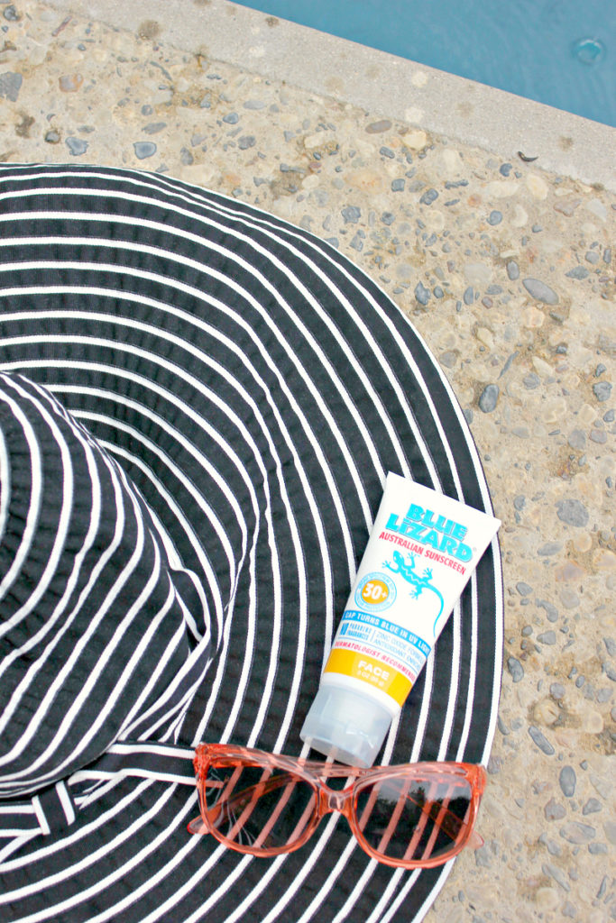 Black and White beach hat, Oakleys and Sunscreen.