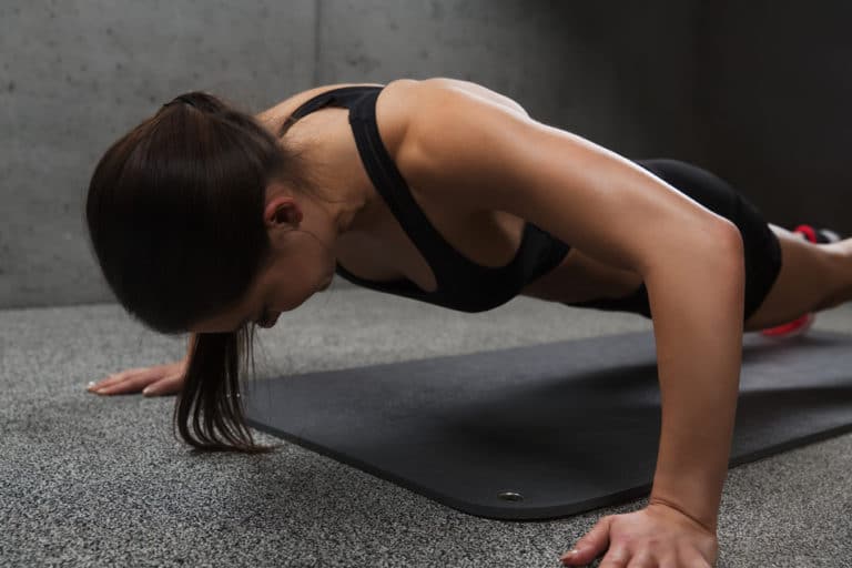 woman doing push-ups in gym