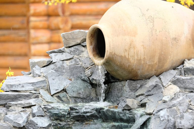 Decorative garden waterfall made with stone jar