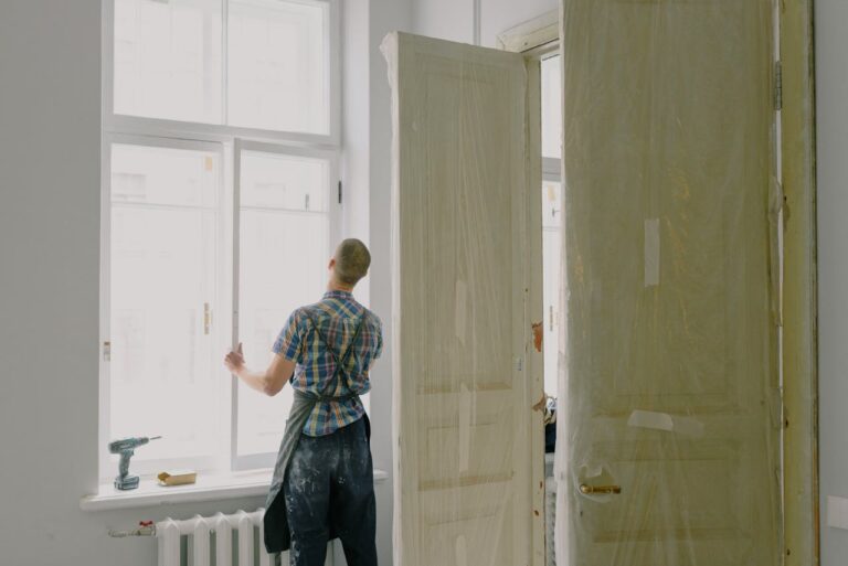 Faceless handyman installing window in new house